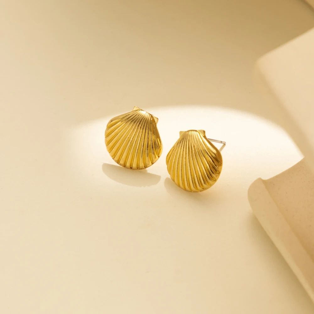 Vintage Shell Design Stud Earrings for Women on a beige surface under soft lighting, showcasing the latest in women's fashion trends.