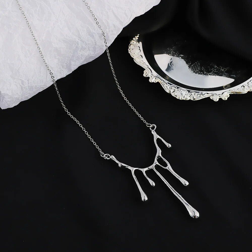 Elegant Liquid Drop Shape Yarn Pendant Necklace with a pendant shaped like a tree branch, showcasing the latest fashion trends, displayed on a white lace background beside a small silver tray.
