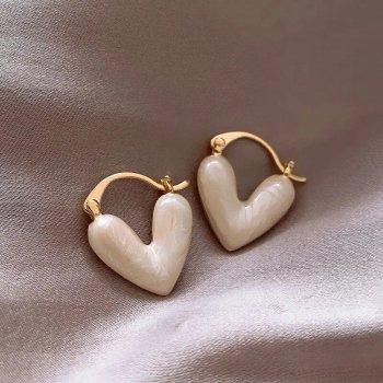 A pair of Elegant Heart Small Drop Earrings for Women with gold clasps, embodying the latest fashion trends, resting on a silky beige fabric.
