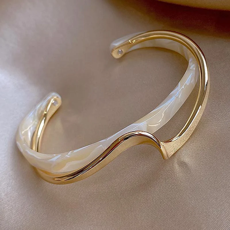 Geometric Metal Charm Bracelet for Women on a soft beige surface.