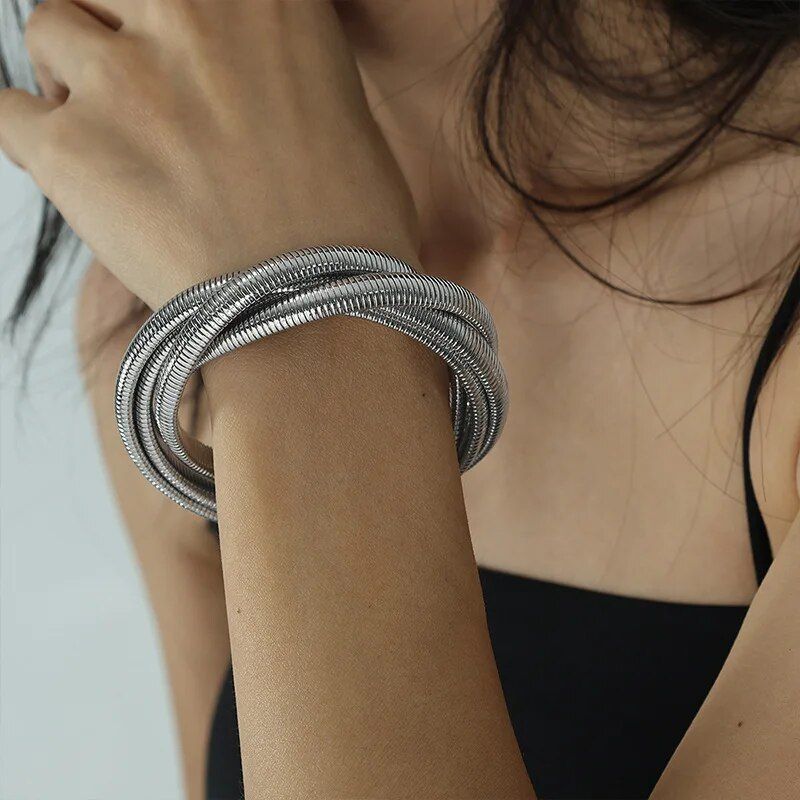 A woman wearing a black sleeveless top, displaying a Trendy Punk Style Gold-Plated Geometric Womens Bangle on her right wrist as a striking fashion accessory.