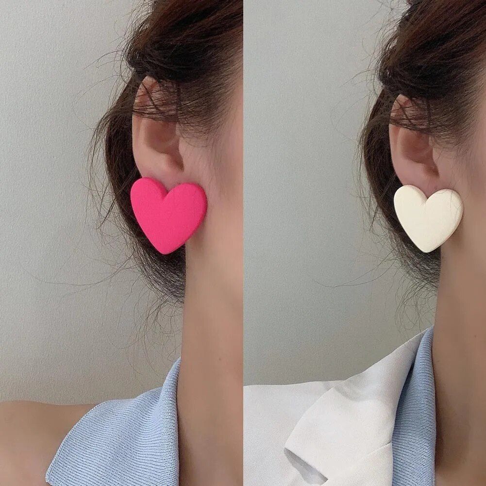 Two side-by-side images showcasing a woman's ear adorned with Colorful Heart-Shaped Acrylic Earrings for Women; one pink and the other white, exemplifying new fashion style.