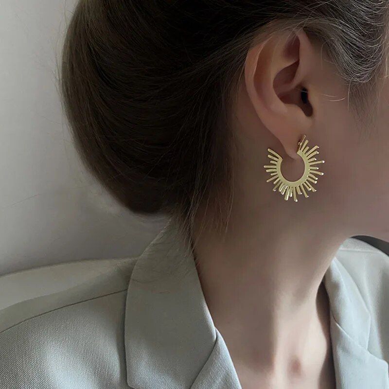 Woman side profile showing a Chic Sunflower Hoop Earring, wearing a light grey blazer styled with the latest fashion accessory.