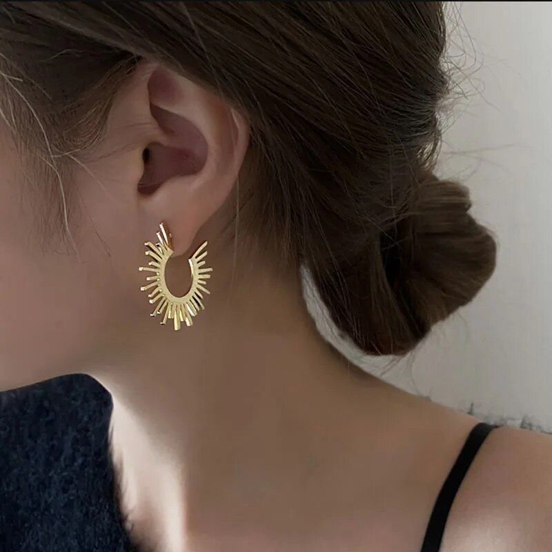 A woman with her hair in a bun wearing Chic Sunflower Hoop Earrings for Women.