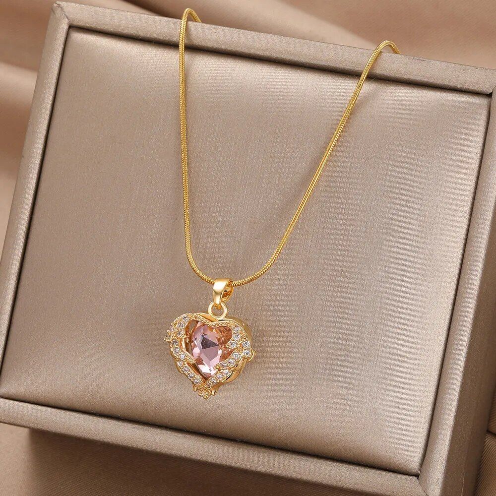 Gold-plated enamel red heart pendant necklace with a pink gemstone, displayed in an open beige box, reflecting the latest women's fashion trends.